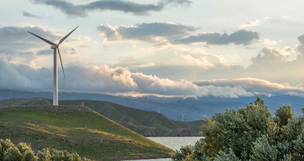 wind-power-turbine-hill-front-cloudy-sky